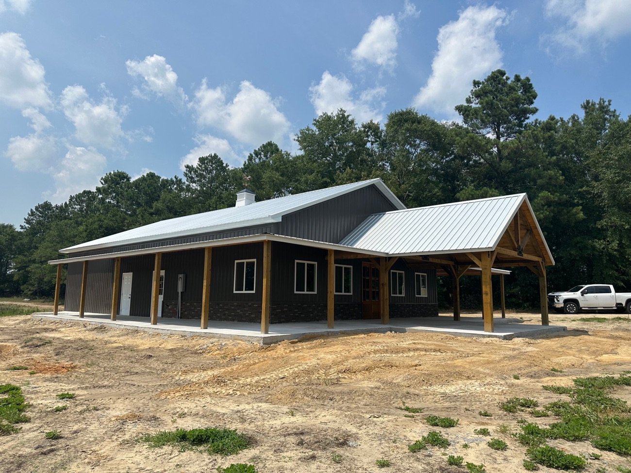 Brown barndominium with a covered porch and metal roof