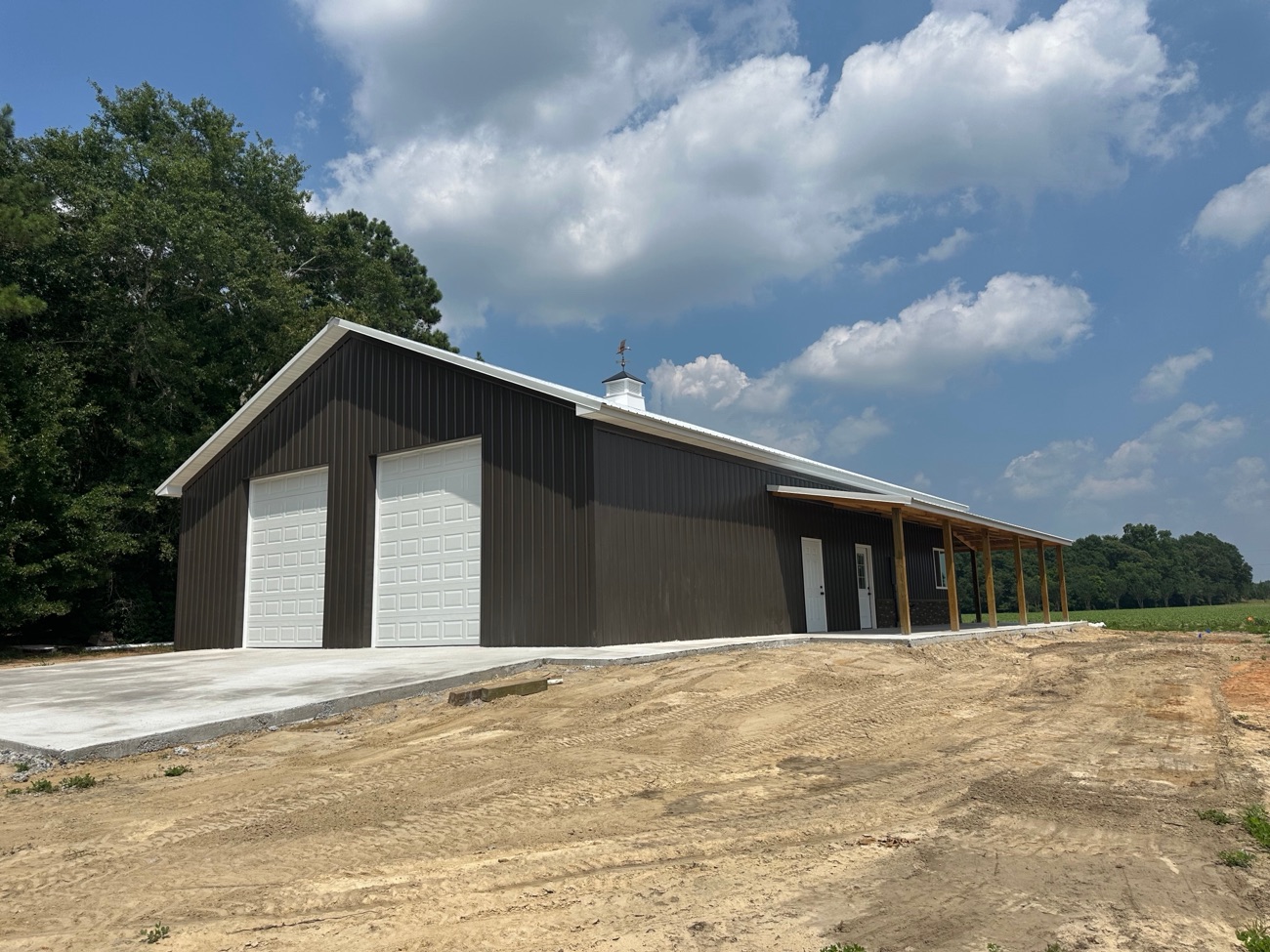 Dark brown pole barn with white overhead doors