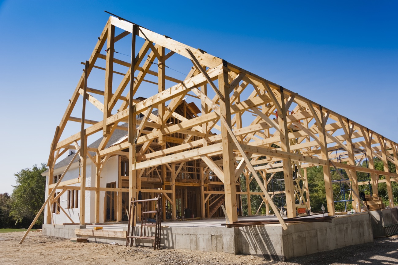 Timber-frame structure under construction with exposed wood trusses